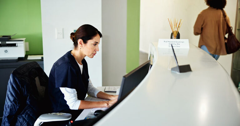 Clinic, receptionist and woman on computer for medical service, appointment and administration. Healthcare, hospital and dental assistant at front desk for planning, dental schedule and information